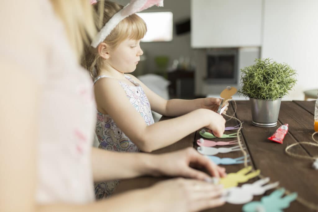 une petite fille fabrique une guirlande