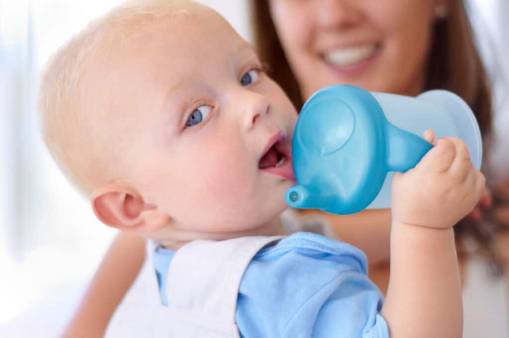 Hydratation d'un bébé grâce à une gourde.